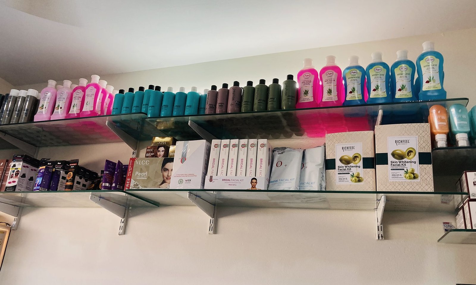 Glass shelves lined with shampoos, conditioners and skincare